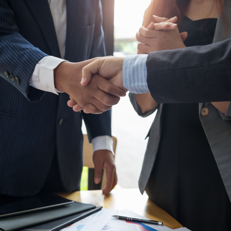 Individuals conducting business and shaking hands