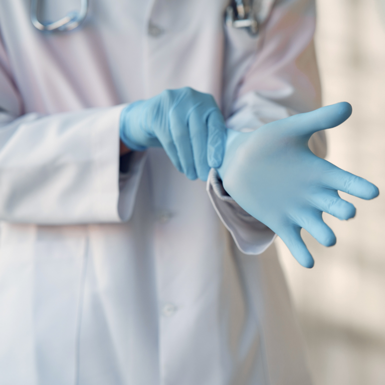 Close up of medical professional placing on gloves