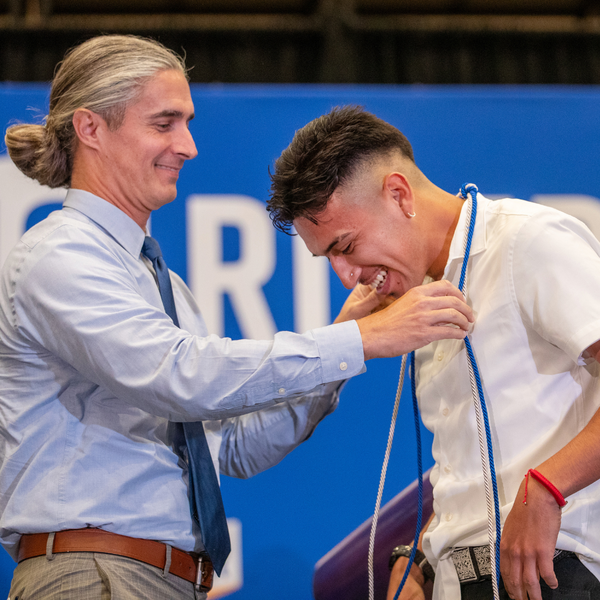 Honors student getting corded by faculty mentor