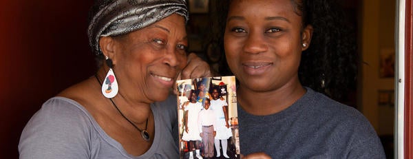 Deidre Reyes alongside her mother Sally Reyes holding a family photograph