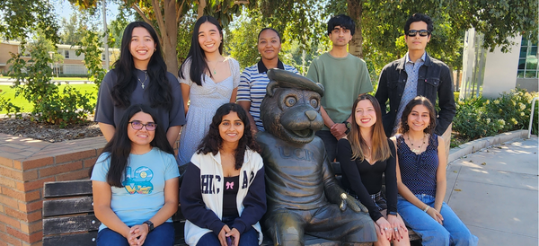 University Honors Ambassadors sitting on bench with Scottie statue